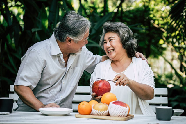 果物を食べる笑顔の老夫婦